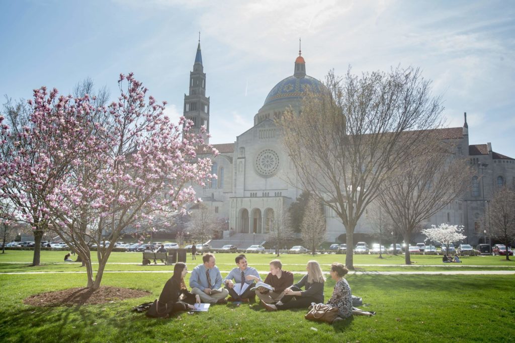 JPII Institute students a sunny spring day with cherry blossoms on the lawn.