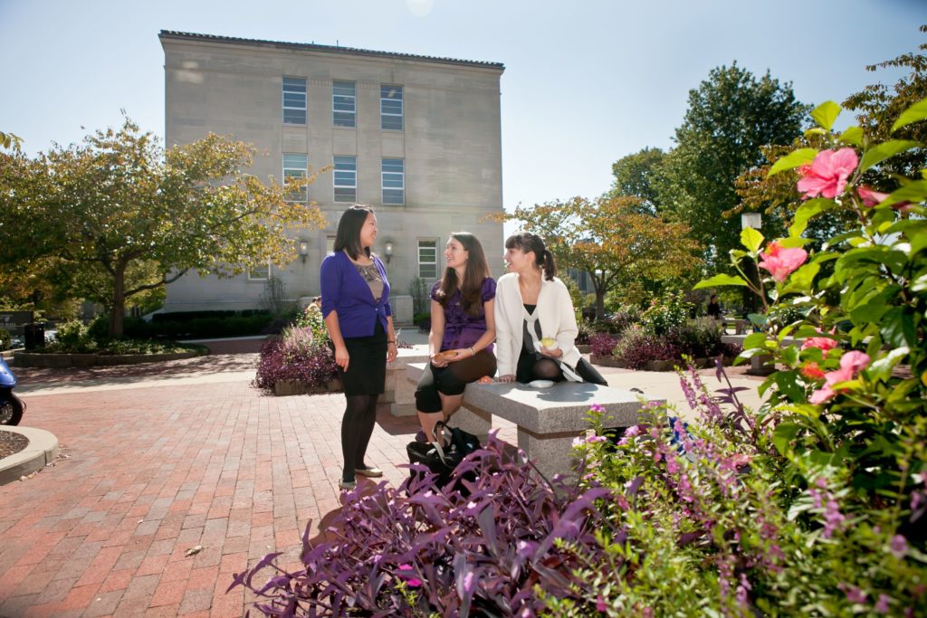 Three students talking in a court yard