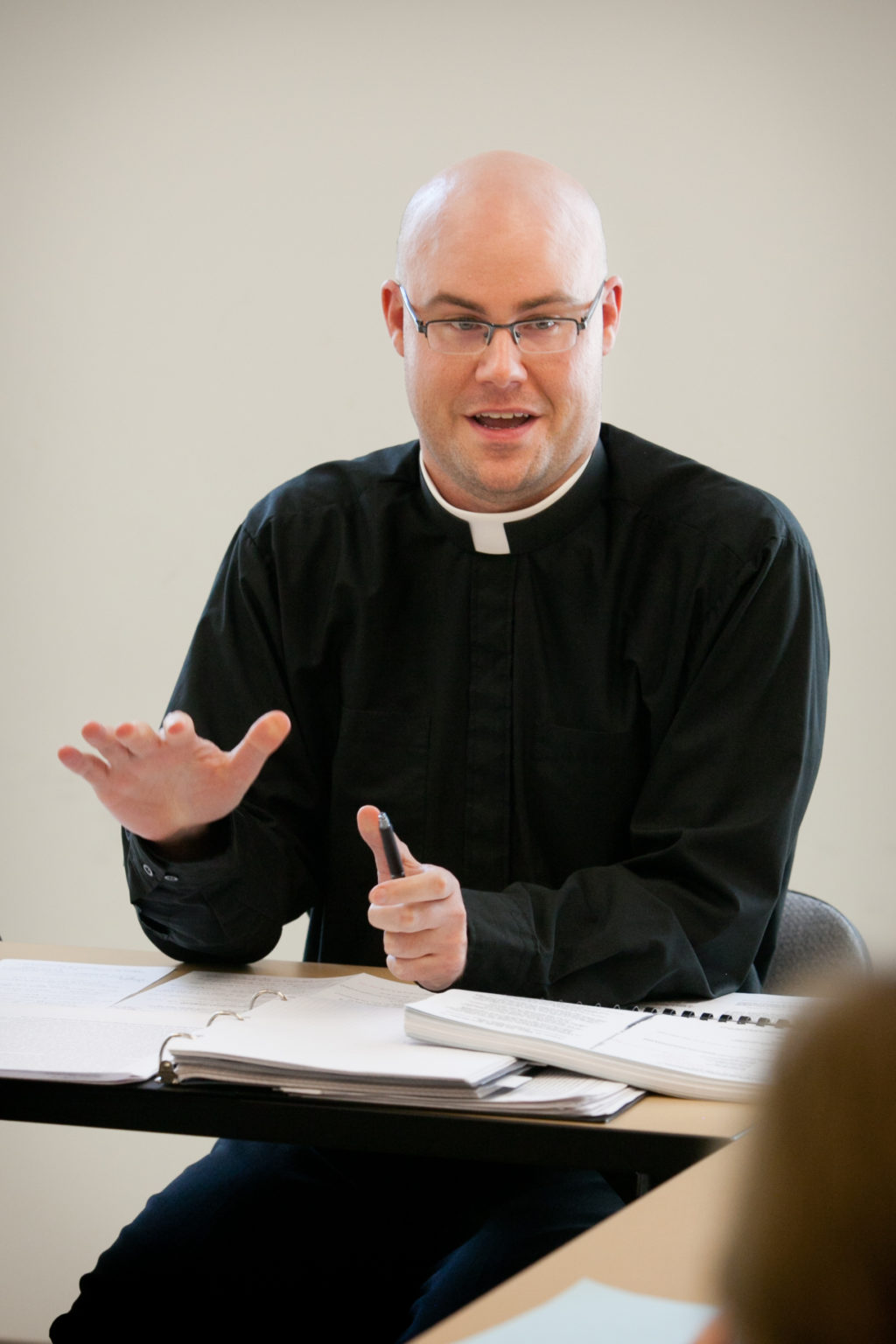 A priest speaking in class