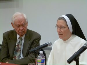 A nun and a man sitting next to each other at a conference