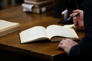 Open book with a persons hand in frame